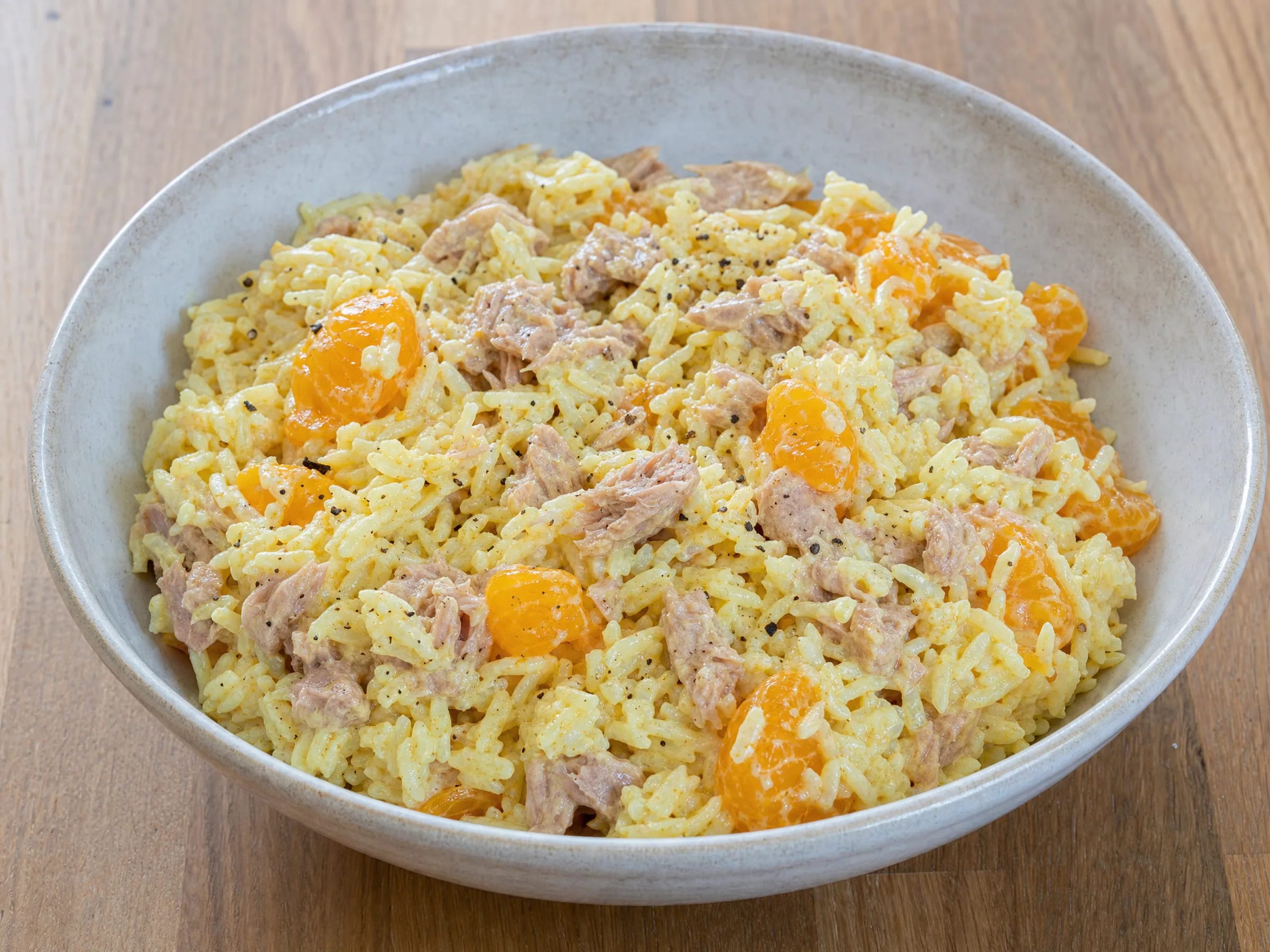 Reissalat mit Curry, Mandarinen und Thunfisch fertig angerichtet