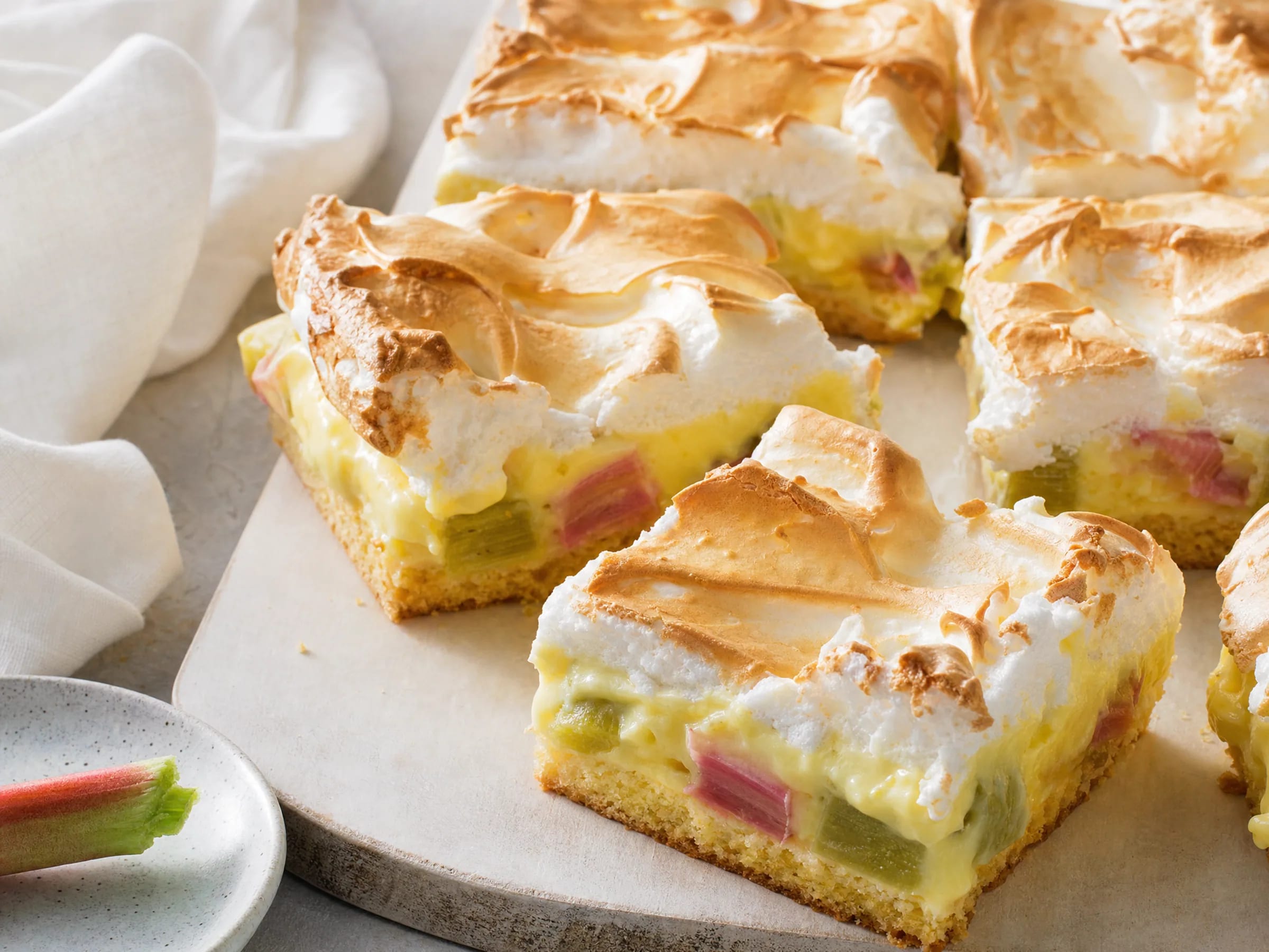 Rhabarberkuchen vom Blech mit Pudding und Baiser fertig angerichtet