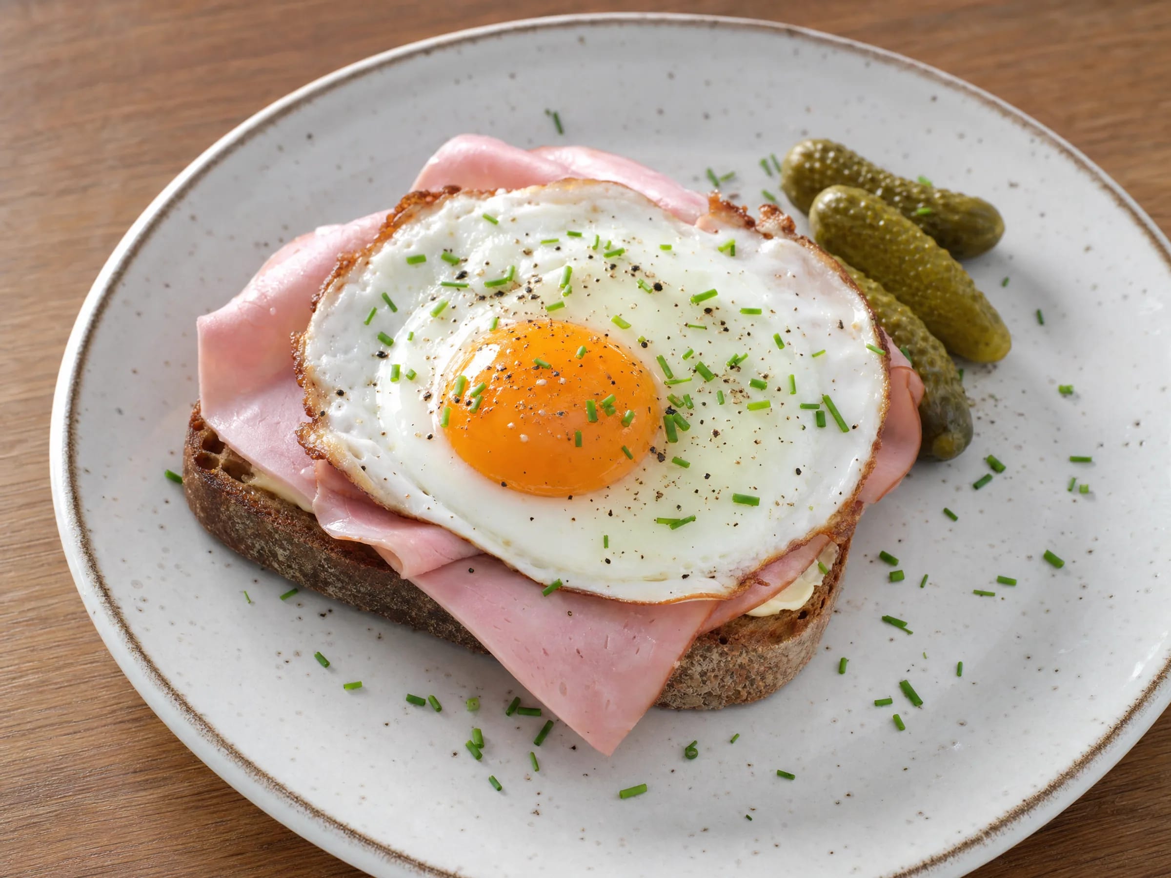 Strammer Max mit Schinken, Spiegelei und geröstetem Roggenmischbrot fertig angerichtet