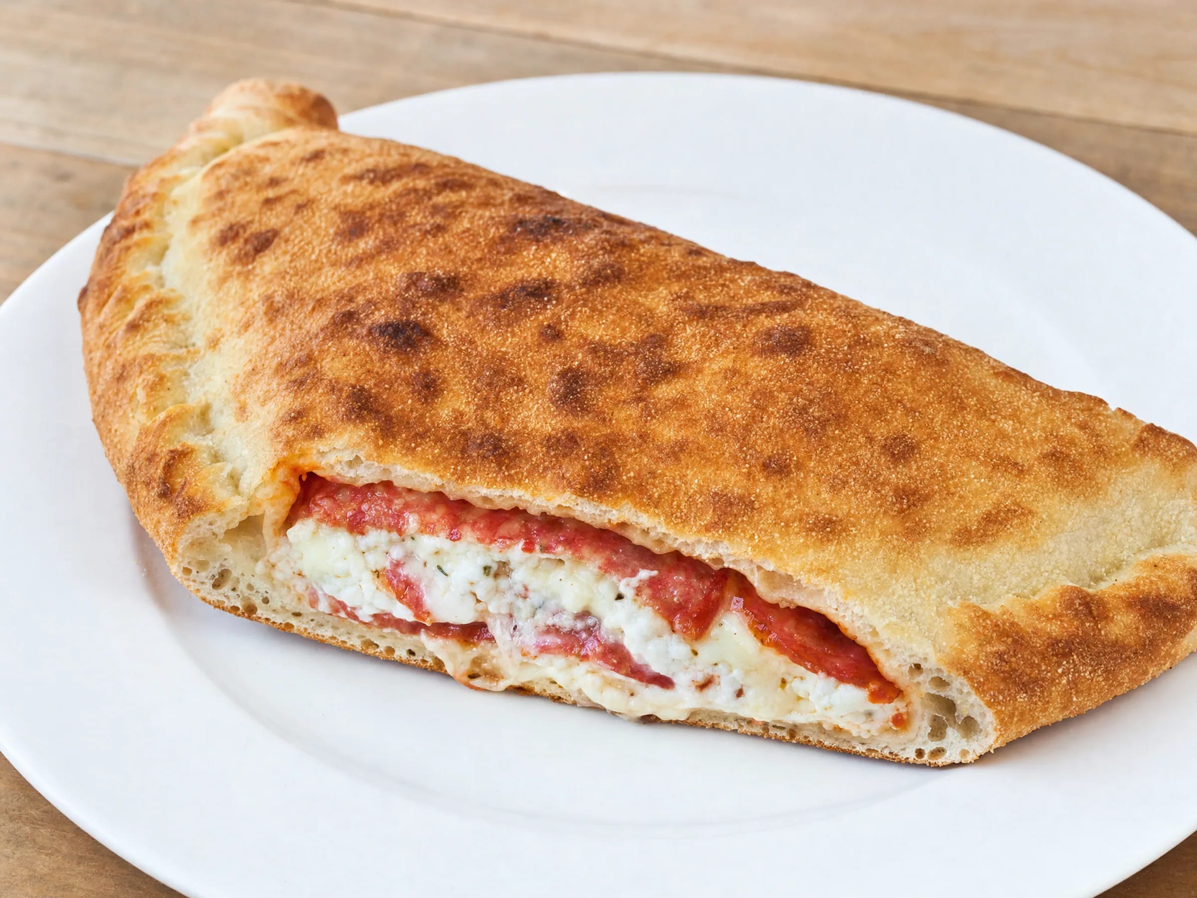 Calzone aus dem Ofen mit Tipo-00-Teig und Ricotta-Salami-Füllung fertig angerichtet