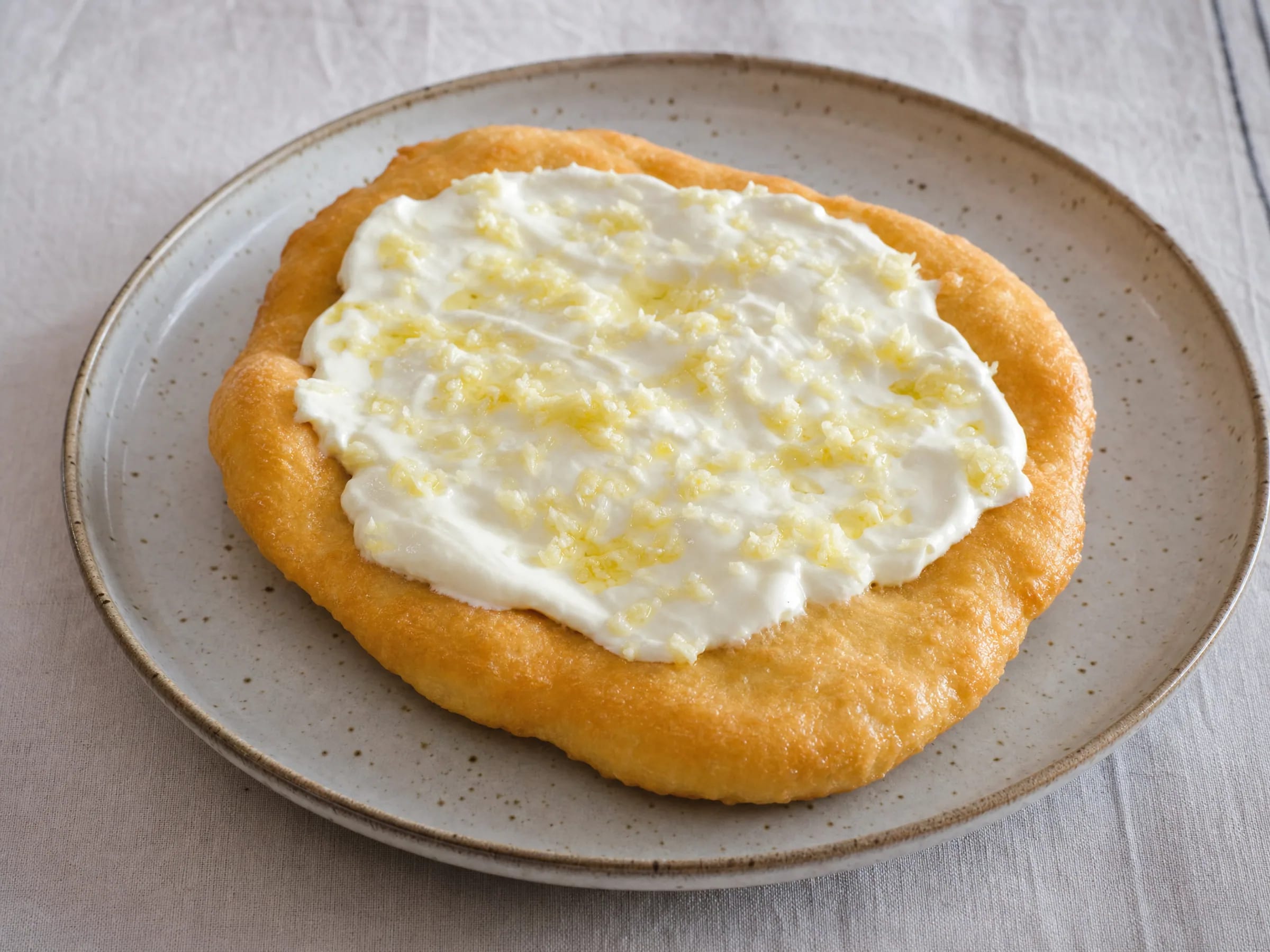 Lángos mit luftigem Hefeteig, Knoblauch und Sauerrahm fertig angerichtet