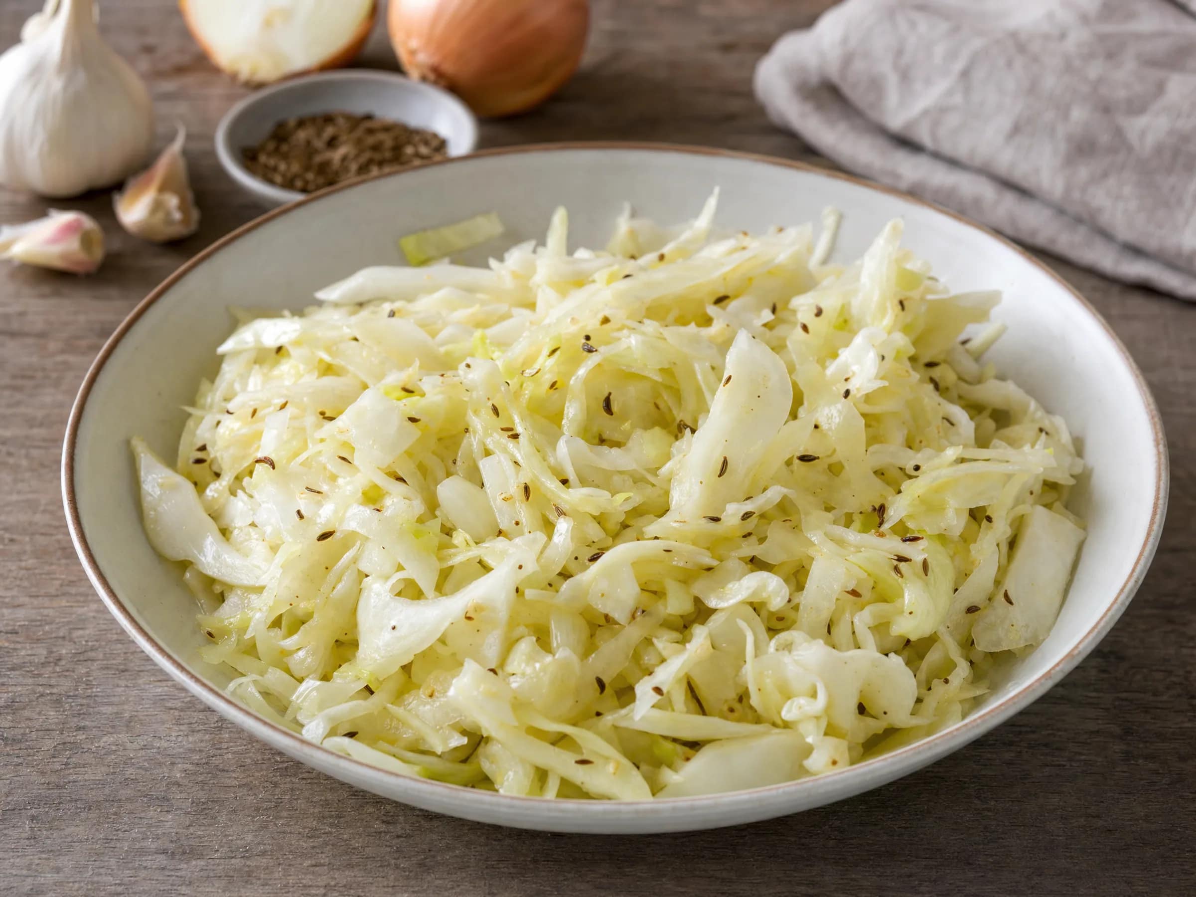 Krautsalat bayrisch – fein gehobelt mit warmem Kümmel-Dressing